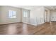 Bright hallway with wood-look floors, white banister, and a view of the living room with windows at 13695 Emerald Lake St, Parker, CO 80138