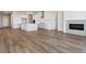 Open-concept living space with wood floors, fireplace, and a kitchen with a center island and white cabinets at 13695 Emerald Lake St, Parker, CO 80138