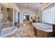 Bright bathroom featuring a tiled shower, soaking tub, and decorative chandelier at 7408 Sodalite Way, Castle Rock, CO 80108