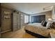 Neutral bedroom with accent wall, dark closet doors, and large armoire at 7408 Sodalite Way, Castle Rock, CO 80108