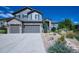Charming two-story home featuring a well-manicured lawn, a three-car garage, and beautiful stone and siding accents at 7408 Sodalite Way, Castle Rock, CO 80108