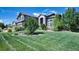 Beautifully landscaped front yard with a lush lawn, mature trees, and a stately two-story residence with a three-car garage at 7408 Sodalite Way, Castle Rock, CO 80108