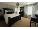 Spacious main bedroom with a dark wood furniture set, decorative lighting and neutral-toned walls and carpet at 7408 Sodalite Way, Castle Rock, CO 80108