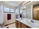 Double vanity bathroom with coordinated towels, mirrors, and lighting fixtures at 3823 S Uravan St, Aurora, CO 80013