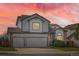 Two-story home featuring a three-car garage and sunset sky at 3823 S Uravan St, Aurora, CO 80013