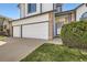 Two-story home with a three-car garage, tidy lawn, and brick detailing around the entrance at 3823 S Uravan St, Aurora, CO 80013