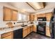 Kitchen featuring light oak cabinets, black appliances, and granite countertops at 3823 S Uravan St, Aurora, CO 80013
