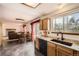 Open kitchen with wood cabinets, granite counters, black appliances, and view into living room and dining area at 3823 S Uravan St, Aurora, CO 80013