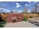 Fenced backyard featuring a brick outdoor kitchen and garden area, perfect for entertaining and relaxation at 4521 E Jewell Ave, Denver, CO 80222