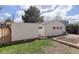 Spacious backyard with a lush lawn, an adjacent white structure, and a garden bed awaiting your personal touch at 4521 E Jewell Ave, Denver, CO 80222
