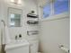 Clean bathroom with modern sink, toilet, mirror, and decorative shelves at 4521 E Jewell Ave, Denver, CO 80222