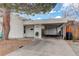 Exterior shot showing front entrance, covered parking, brick pillar, and well-maintained yard at 4521 E Jewell Ave, Denver, CO 80222