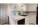Corner of kitchen featuring white cabinets, neutral countertop, black appliances and tile flooring at 4521 E Jewell Ave, Denver, CO 80222