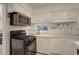 Bright kitchen featuring stainless steel appliances, white cabinetry, and natural light at 4521 E Jewell Ave, Denver, CO 80222