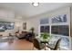 Living room with an open floor plan, including a seating area and small table in front of bright windows at 4521 E Jewell Ave, Denver, CO 80222