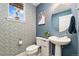 Stylish powder room features patterned wallpaper, vessel sink, and a round mirror at 7808 W 43Rd Pl, Wheat Ridge, CO 80033