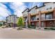 View of townhomes featuring a balcony with overhead wood feature and manicured landscaping at 7808 W 43Rd Pl, Wheat Ridge, CO 80033