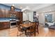 Bright open kitchen and dining area with stainless steel appliances, dark wood cabinets, and an adjacent living space at 7808 W 43Rd Pl, Wheat Ridge, CO 80033