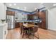 Spacious kitchen and dining area with stainless steel appliances, dark wood cabinetry, and a large table at 7808 W 43Rd Pl, Wheat Ridge, CO 80033