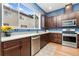 The modern kitchen boasts stainless steel appliances, plenty of cabinet space and a view through a large window at 7808 W 43Rd Pl, Wheat Ridge, CO 80033