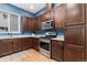 Well-equipped kitchen showcasing dark wood cabinets, stainless steel appliances, granite countertops, and modern fixtures at 7808 W 43Rd Pl, Wheat Ridge, CO 80033