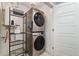 A modern, stacked washer and dryer set with shelving in a convenient laundry room at 7808 W 43Rd Pl, Wheat Ridge, CO 80033