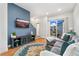 Bright living room boasts a blue accent wall, hardwood floors, and a sliding door to the outside at 7808 W 43Rd Pl, Wheat Ridge, CO 80033