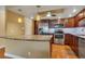 A well-lit kitchen featuring stainless steel appliances, wooden cabinetry, granite countertops, and a breakfast bar at 13961 E Marina Dr # 314, Aurora, CO 80014