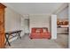 Cozy living room with neutral carpet, an orange couch with pillows, and a glimpse into the kitchen at 13961 E Marina Dr # 314, Aurora, CO 80014