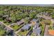 Aerial view showcases property, neighborhood, mature trees, and mountain views in the distance at 4635 Teller St, Wheat Ridge, CO 80033