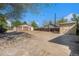 Large concrete backyard with detached garage, shed, and wood fence under a bright blue sky at 4635 Teller St, Wheat Ridge, CO 80033