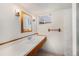 Small bathroom with wood-trimmed mirror, a single sink vanity, and natural light from the window at 4635 Teller St, Wheat Ridge, CO 80033