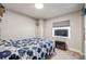 Cozy bedroom with a floral bedspread, window, and electric fireplace for added comfort at 11727 Oswego St, Commerce City, CO 80640