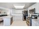 Bright kitchen features stainless appliances, granite counters, and a view into the living room at 11727 Oswego St, Commerce City, CO 80640