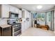 Bright kitchen features stainless appliances, granite counters, subway tile backsplash and backyard views at 11727 Oswego St, Commerce City, CO 80640