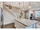 Bright kitchen island with granite countertop, decor, and view of staircase at 6570 Parterre N Pkwy # 6, Thornton, CO 80602