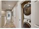 Hallway with laundry room nook that has a stacked, white front-load washer and dryer in an open closet space at 6570 Parterre N Pkwy # 6, Thornton, CO 80602