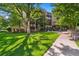 Exterior view of building with manicured lawn and mature trees, showing pedestrian path at 7040 E Girard Ave # 207, Denver, CO 80224