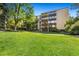 Exterior view of the property showcasing its well-maintained lawn, mature trees, and multi-story facade at 7040 E Girard Ave # 207, Denver, CO 80224