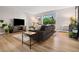 Bright living room with a gray sofa, modern tables, wood-look floors, and sliding glass doors at 7040 E Girard Ave # 207, Denver, CO 80224