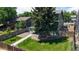 Landscaped backyard featuring a well-maintained lawn, mature trees, and an elevated deck at 3883 S Fraser St, Aurora, CO 80014