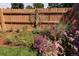 Landscaped backyard garden with vibrant flowers and tree-of-life sculpture on fence at 3883 S Fraser St, Aurora, CO 80014