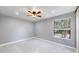 Cozy bedroom with plush carpet, ceiling fan, and bright natural light from a window at 3883 S Fraser St, Aurora, CO 80014
