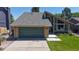 Green exterior of home with a green garage door, brick accents, and well-maintained landscaping at 3883 S Fraser St, Aurora, CO 80014