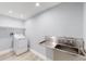 Functional laundry room includes a stainless-steel utility sink and a modern washer-dryer at 3883 S Fraser St, Aurora, CO 80014