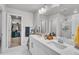 Bright bathroom with double vanity, marble flooring, large mirror, and walk-in closet at 8145 Monte Vista Cir, Littleton, CO 80125