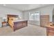Spacious bedroom with a large window, neutral carpet, and dark wood furniture at 8145 Monte Vista Cir, Littleton, CO 80125