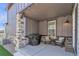 Cozy covered patio with grill, chairs, and string lights at 8145 Monte Vista Cir, Littleton, CO 80125