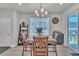Stylish dining area with a wood table, modern chandelier, and sliding glass doors to the patio at 8145 Monte Vista Cir, Littleton, CO 80125