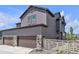 Exterior side view displaying garage, stone accents, and well-kept landscaping at 8145 Monte Vista Cir, Littleton, CO 80125